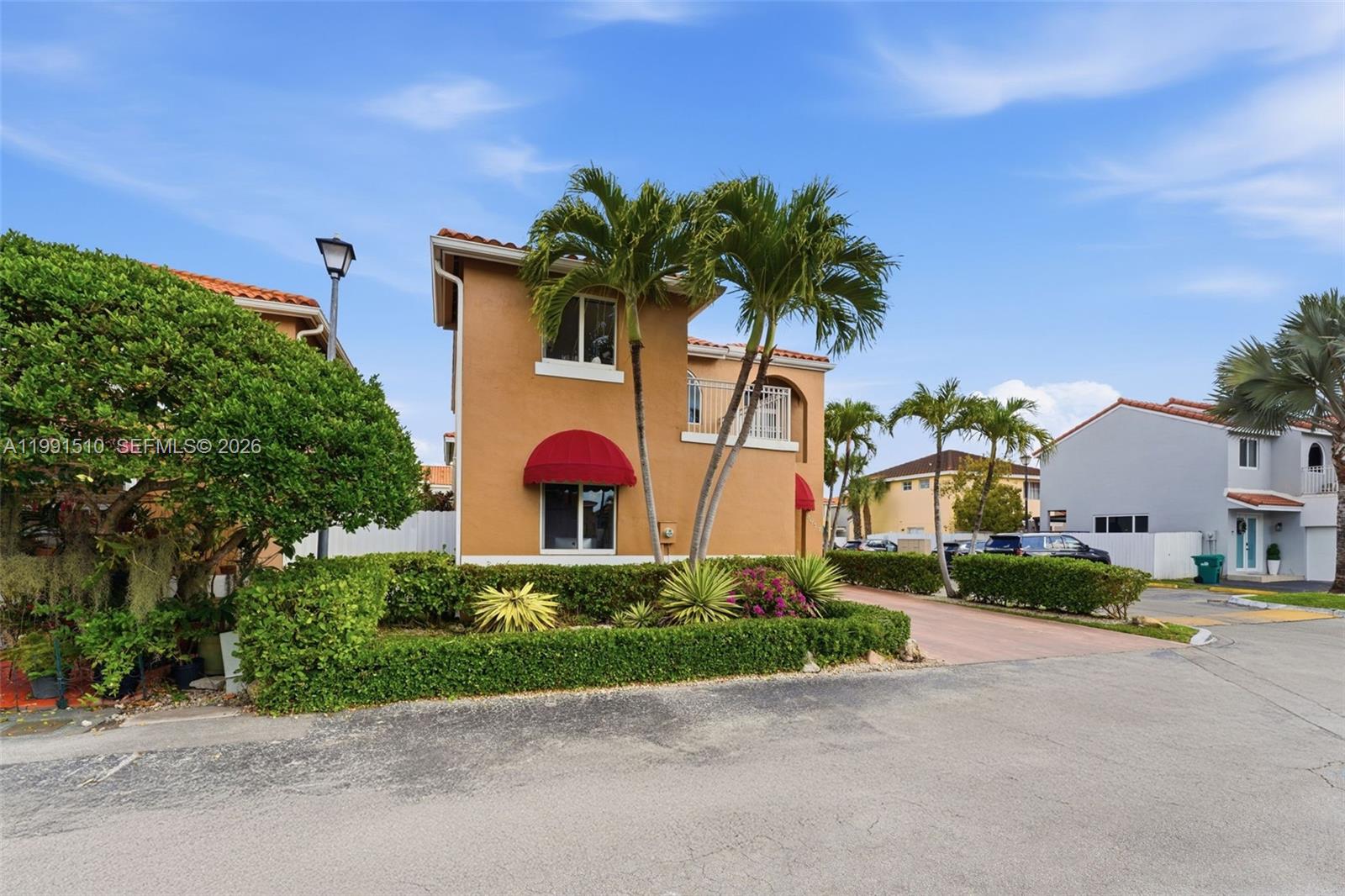 A two-story tan house with a red awning and palm trees sits on a corner — 8657 NW 2nd St, Miami FL 33126, MIAMI, FL