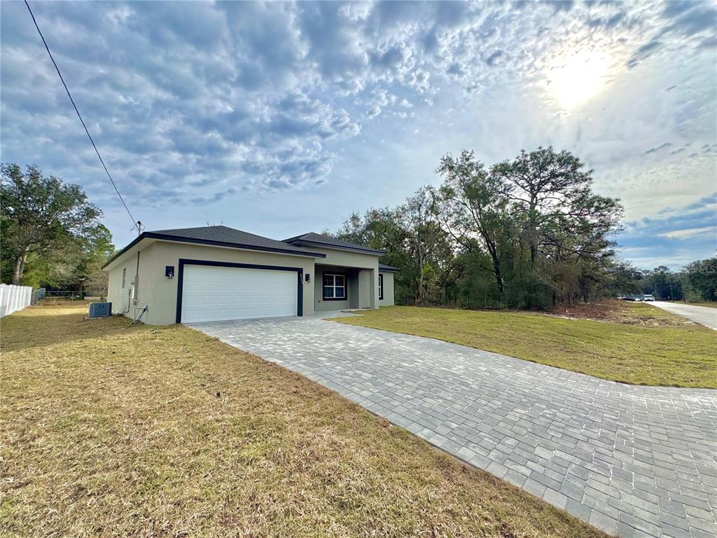 A single-story house with a paved driveway, a two-car garage, and a light-colored exterior — 8593 N MULLER WAY, CITRUS SPRINGS, FL