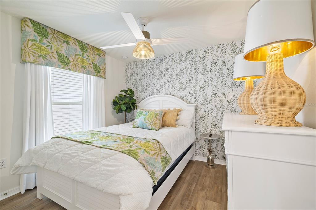 A hallway with light wood-look flooring leads to an open living area with a console table — 915 OVERPOOL AVENUE, DAVENPORT, FL