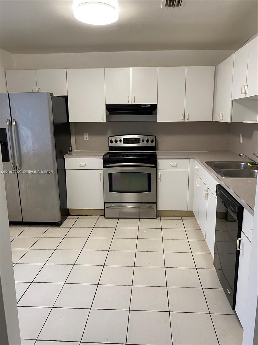 An empty room features white walls, a ceiling fan, and light-colored square floor tiles — 22221 SW 103rd Ct # 0, Miami FL 33190, MIAMI, FL