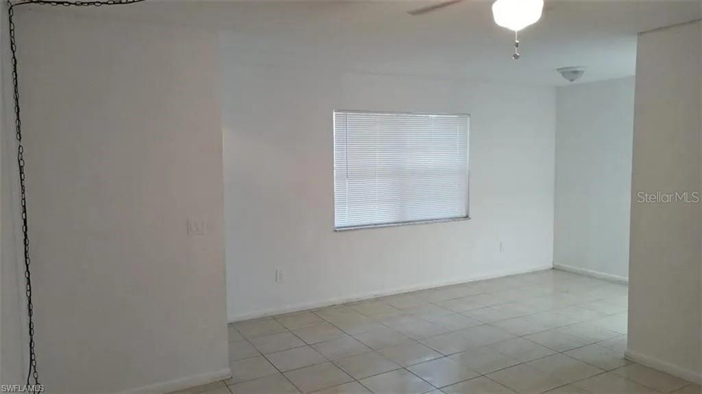 A room with white walls, light-colored tile flooring, a window with blinds, and a ceiling fan — 2524 CONGRESS STREET UNIT #4, FORT MYERS, FL