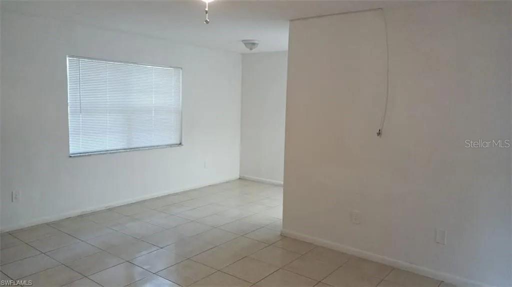An empty room features white walls, light-colored tile flooring, and a single window with blinds — 2524 CONGRESS STREET UNIT #4, FORT MYERS, FL