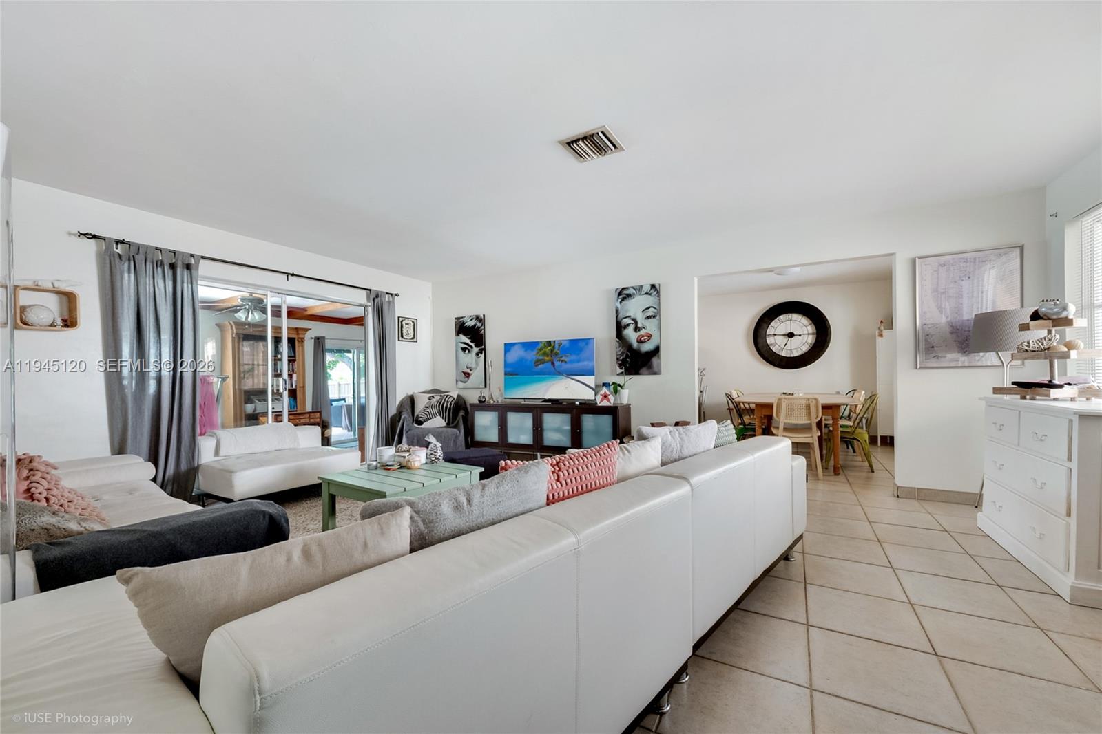 A living room features a white sectional sofa, a television console, and an adjacent dining area — 5700 SW 45th Ter, Miami FL 33155, MIAMI, FL