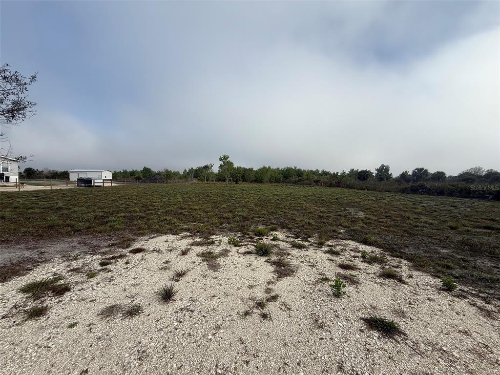 A wide, flat, grassy lot features a patch of gravel in the foreground — 18935 NW 268TH STREET, OKEECHOBEE, FL