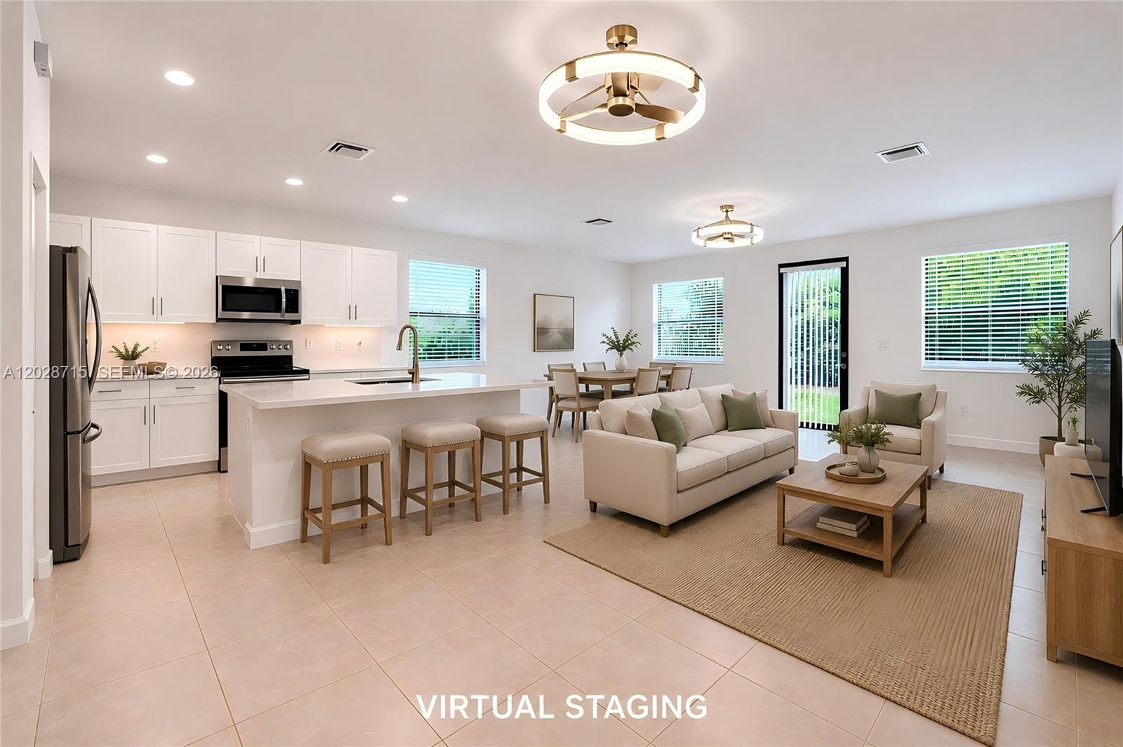 This open-concept living area features a kitchen with white cabinets, an island, and dining space — 3448 W 110th Ter, Hialeah FL 33018, HIALEAH, FL