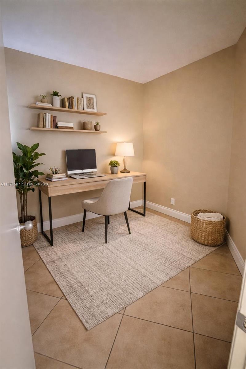 A home office features a desk, chair, floating shelves, and a rug on tile flooring — 6601 SW 116th Ct # 402, Miami FL 33173, MIAMI, FL