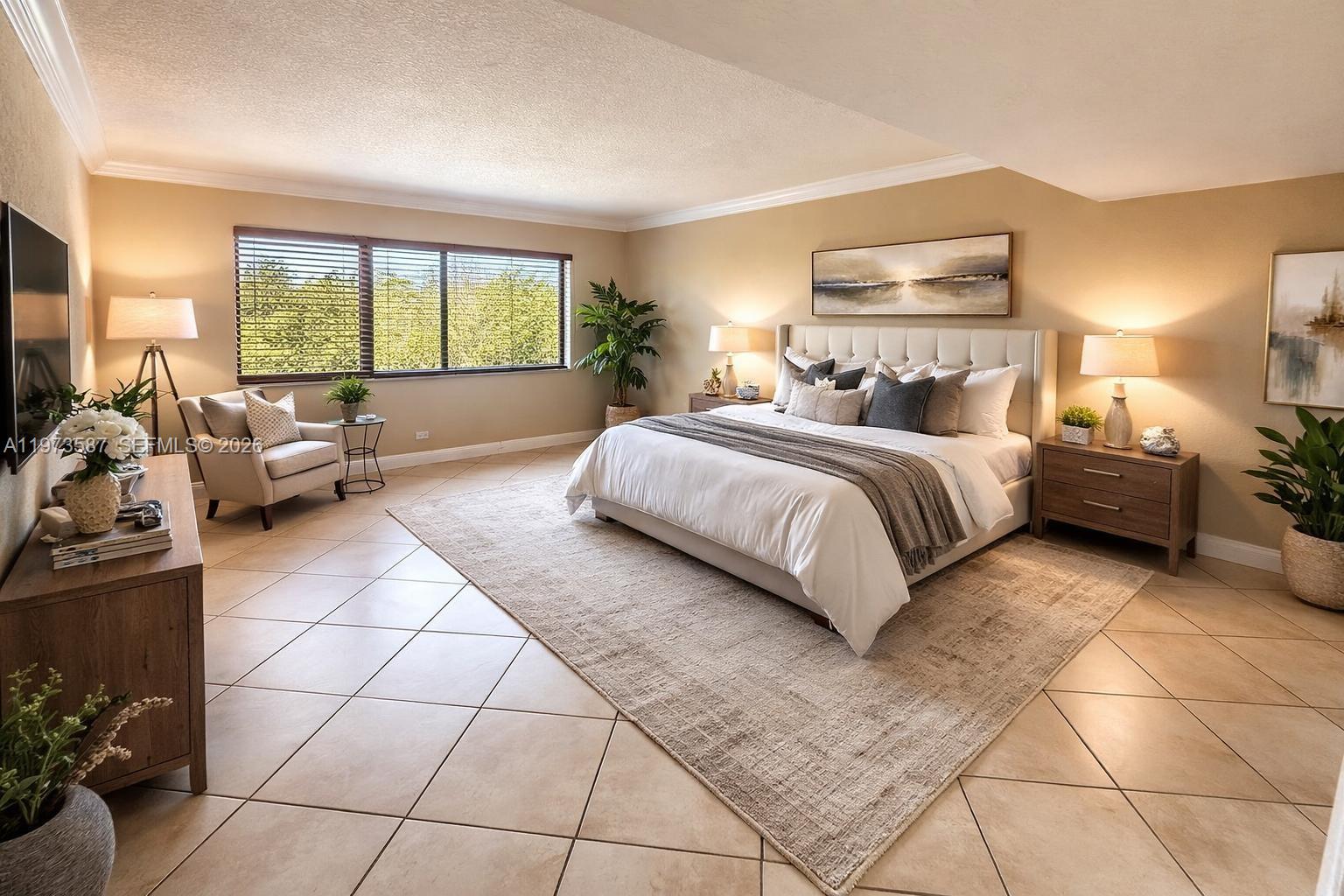 A spacious bedroom features a king-sized bed, tile flooring, and large windows overlooking trees — 6601 SW 116th Ct # 402, Miami FL 33173, MIAMI, FL