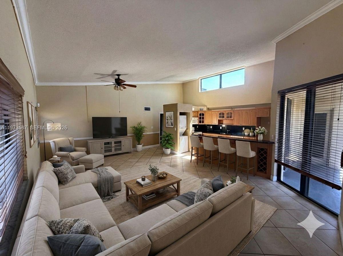 A living room with a sectional sofa, coffee table, and an open kitchen with bar seating — 6601 SW 116th Ct # 402, Miami FL 33173, MIAMI, FL