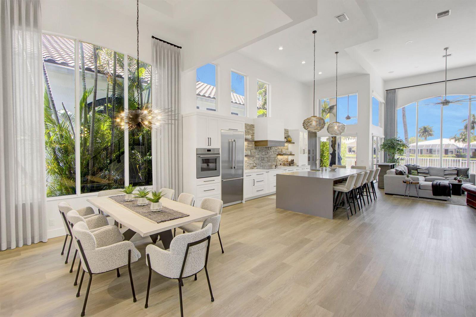 An open-concept kitchen and dining area features white cabinetry, a gray island, and floor-to-ceiling windows — 5463 NW 41st Terrace, Boca Raton FL 33496, BOCA RATON, FL