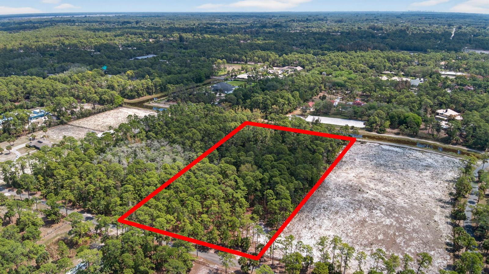 An aerial view shows a rectangular, tree-covered plot of land outlined in red — 1340 Arabian Drive, Loxahatchee FL 33470, LOXAHATCHEE, FL