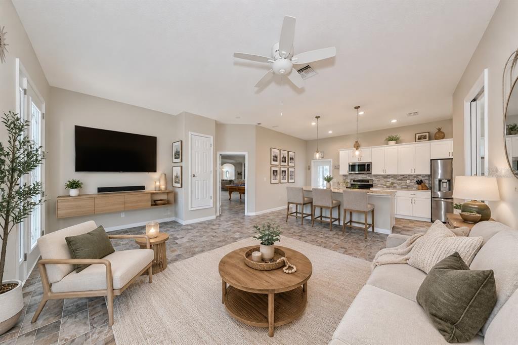 A covered outdoor patio features a stone-topped kitchen with a grill, smoker, and seating — 17706 BRIDLEWOOD COURT, PARRISH, FL