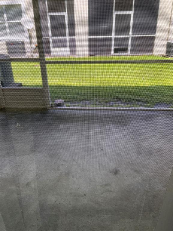 A view of a concrete patio looking out through a screen enclosure toward a grassy yard — 3548 HIGH HAMPTON CIRCLE, TAMPA, FL