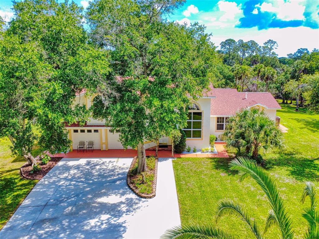 An aerial view of a suburban house with a large tree and concrete driveway — 1205 WILLIAMS ROAD, NEW SMYRNA BEACH, FL
