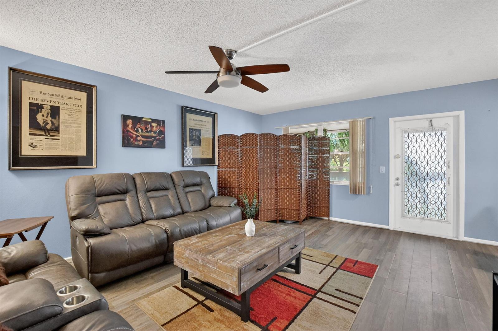 A living room features a brown leather sofa, wood coffee table, and blue walls — 262 Ventnor R, Deerfield Beach FL 33442, DEERFIELD BEACH, FL