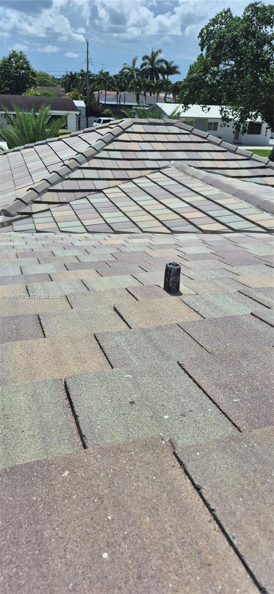 A view of a shingled roof with a plumbing vent pipe and a tiled hip roof — 3711 SW 122nd Ave, Miami FL 33175, MIAMI, FL