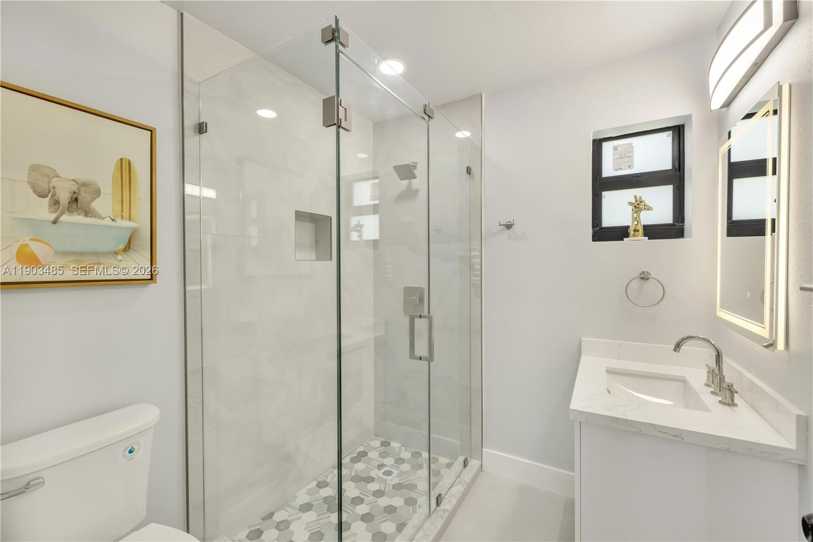 A bathroom features a glass-enclosed shower with patterned tile flooring and a white vanity — 6021 SW 19th St, Miami FL 33155, MIAMI, FL