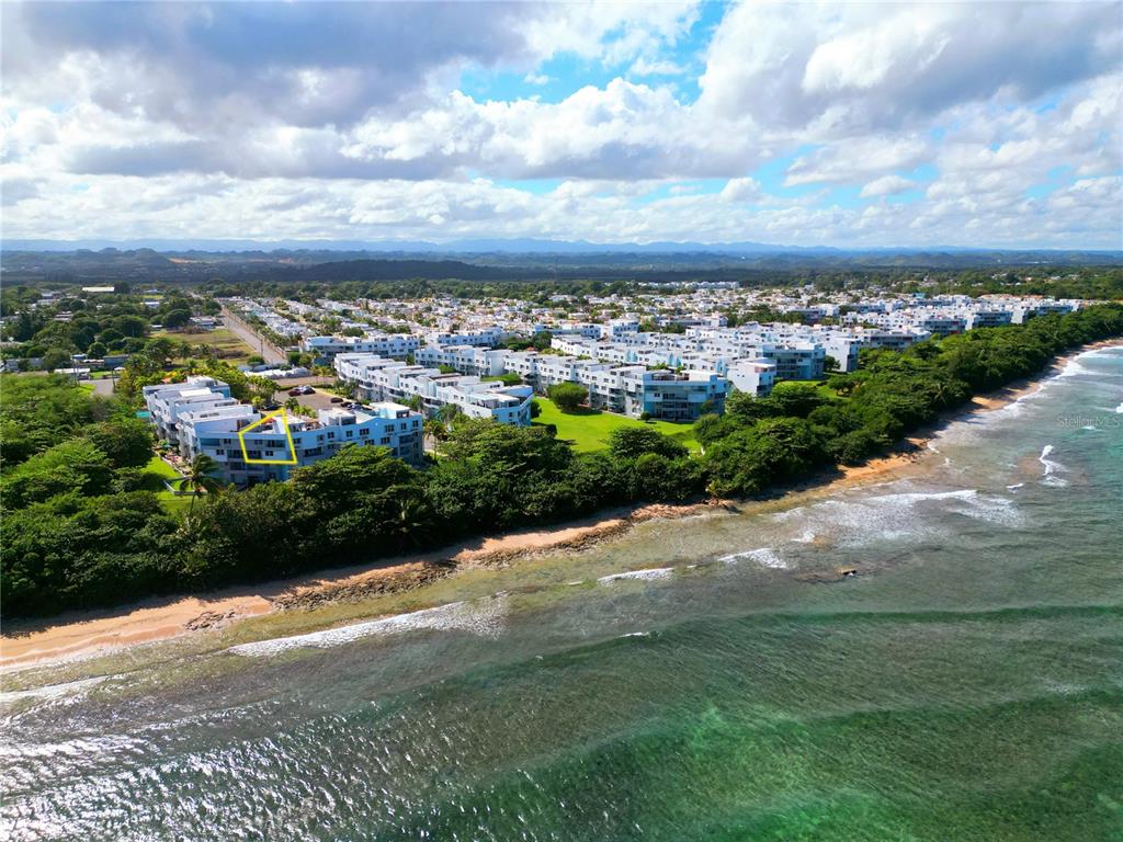 An aerial view of a coastal apartment complex with a yellow outline highlighting one unit — St 686 COND. CHALETS DE LA PLAYA UNIT 579, VEGA BAJA, PR