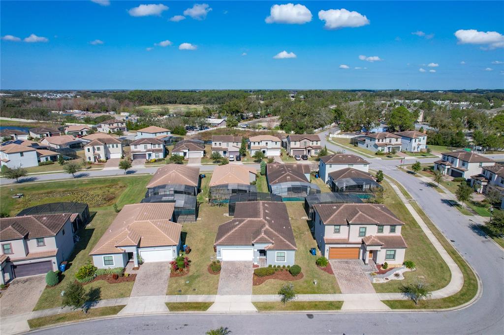 An aerial view shows a suburban neighborhood with several single-family homes and paved streets — 185 BROOKES PLACE, HAINES CITY, FL