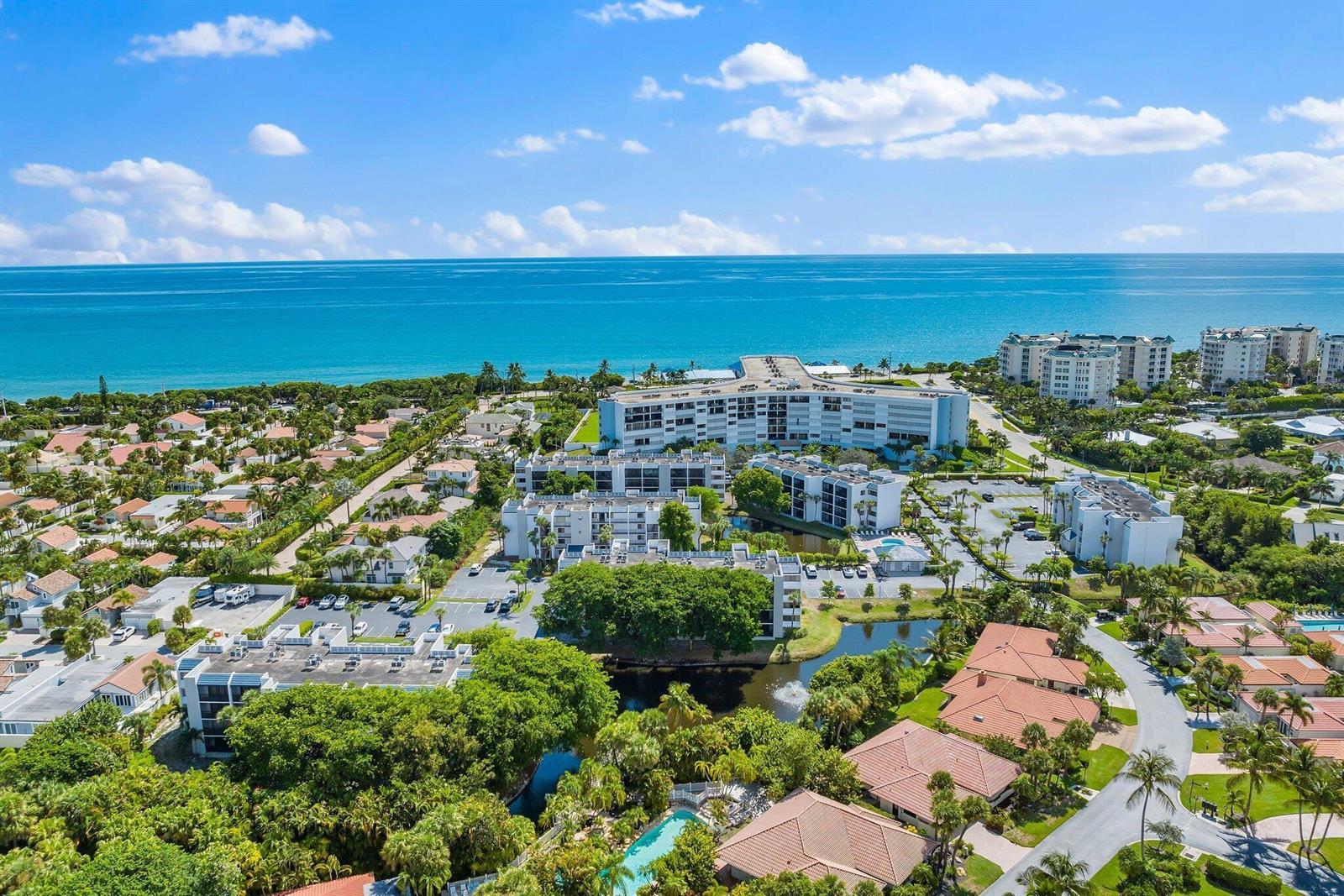 An aerial view shows a coastal residential complex with multiple buildings, pools, and lush landscaping — 1605 S Us Hwy 1 # E104, Jupiter FL 33477, JUPITER, FL
