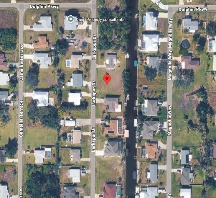 This is an aerial map view showing a vacant residential lot located along a canal — 2702 LARKSPUR DRIVE, PUNTA GORDA, FL