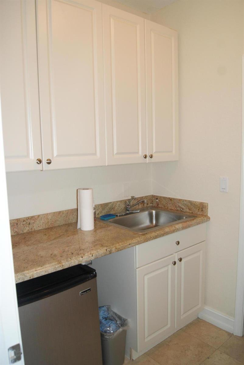A small kitchenette features white cabinets, a granite countertop, and a stainless steel sink — 766 SE 5th Avenue, Delray Beach FL 33483, DELRAY BEACH, FL