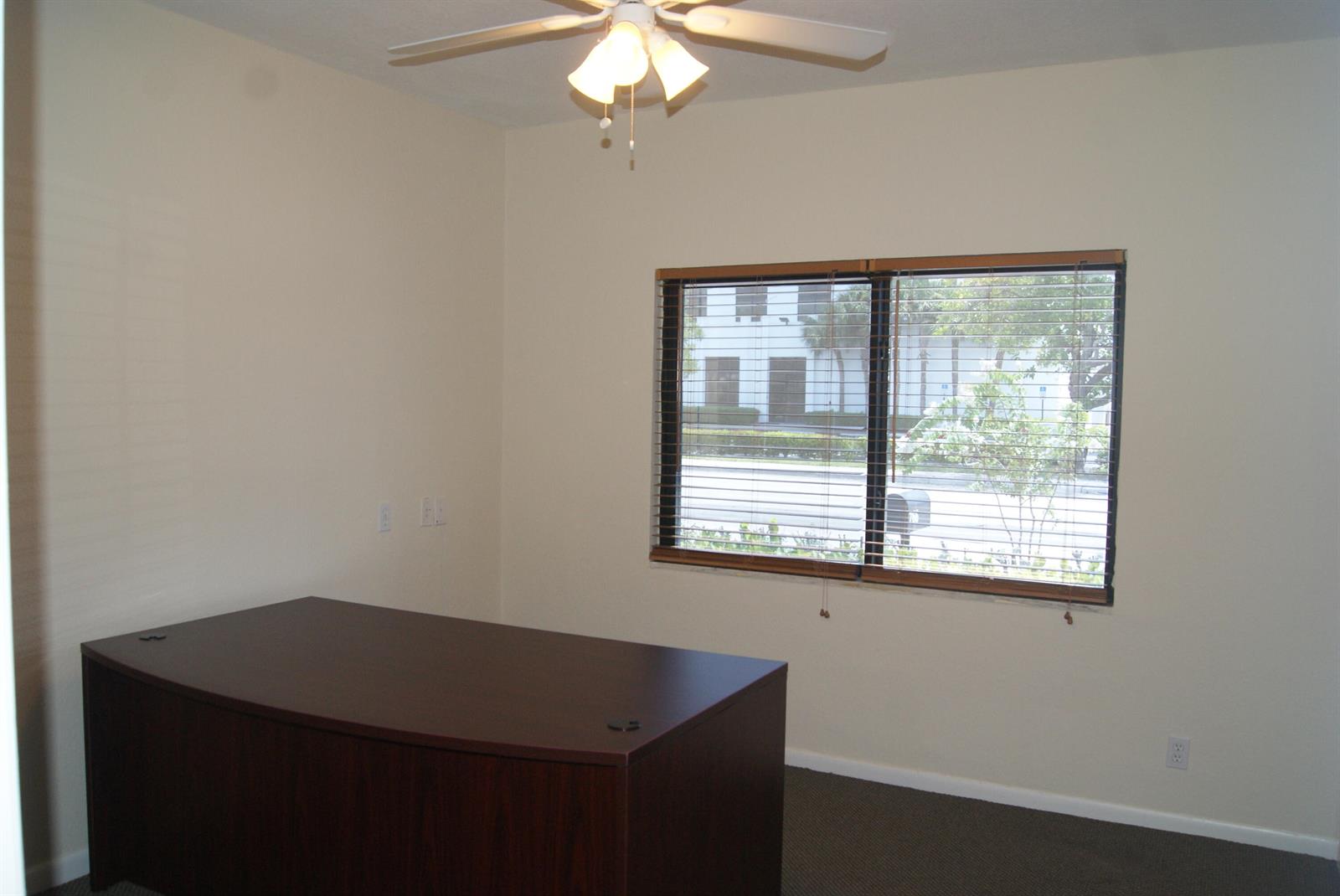 An office room features a dark wood desk, a ceiling fan, and a window with blinds — 766 SE 5th Avenue, Delray Beach FL 33483, DELRAY BEACH, FL