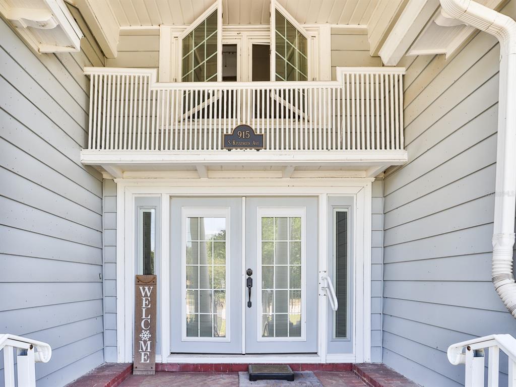 The exterior entrance features double glass doors, a small balcony above, and light gray siding — 915 KISSENGEN AVENUE, BARTOW, FL