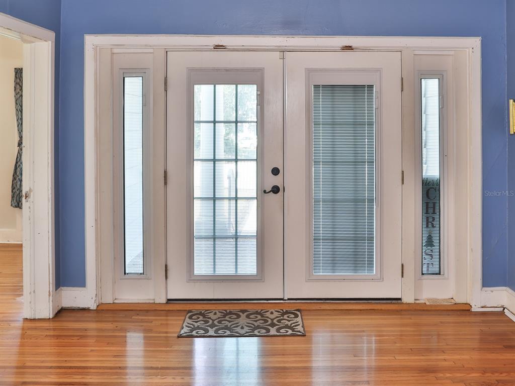 A set of double glass-paneled entry doors with sidelights sits in a blue-walled room — 915 KISSENGEN AVENUE, BARTOW, FL