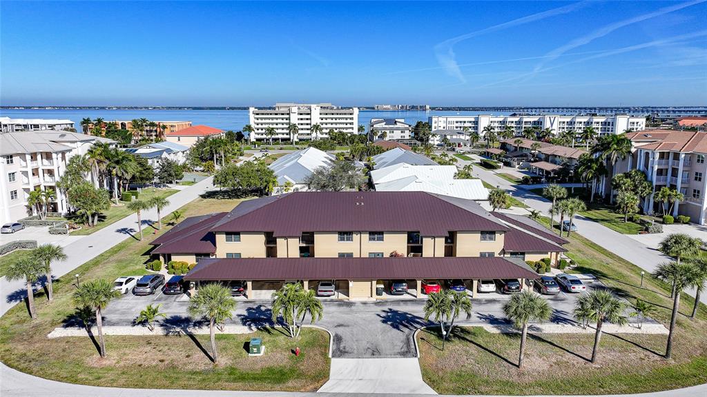 An aerial view of a multi-story residential building with a covered parking area — 240 LEWIS CIRCLE UNIT 513, PUNTA GORDA, FL