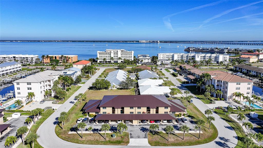 An aerial view shows a multi-story apartment complex surrounded by parking lots and palm trees — 240 LEWIS CIRCLE UNIT 513, PUNTA GORDA, FL