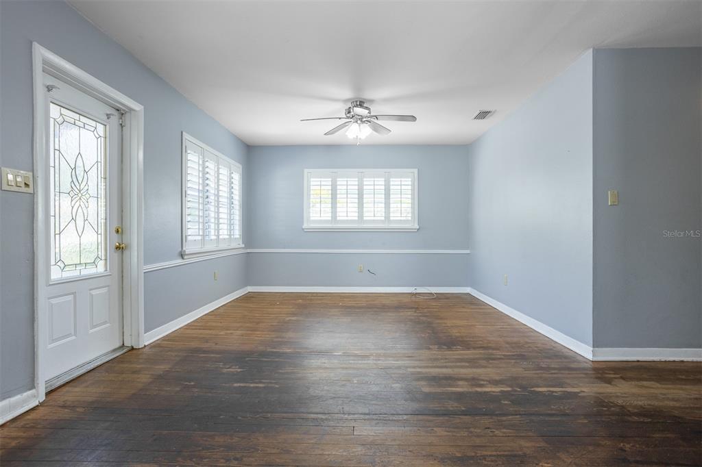 An empty room features light blue walls, a white chair rail, and dark wood flooring — 3306 W FIELDER STREET, TAMPA, FL