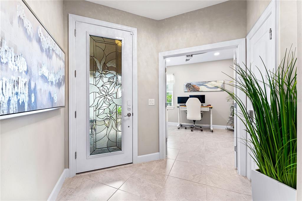 A bright entryway features a white front door with decorative glass and a home office — 14574 MOSSY PINE COURT, NOKOMIS, FL