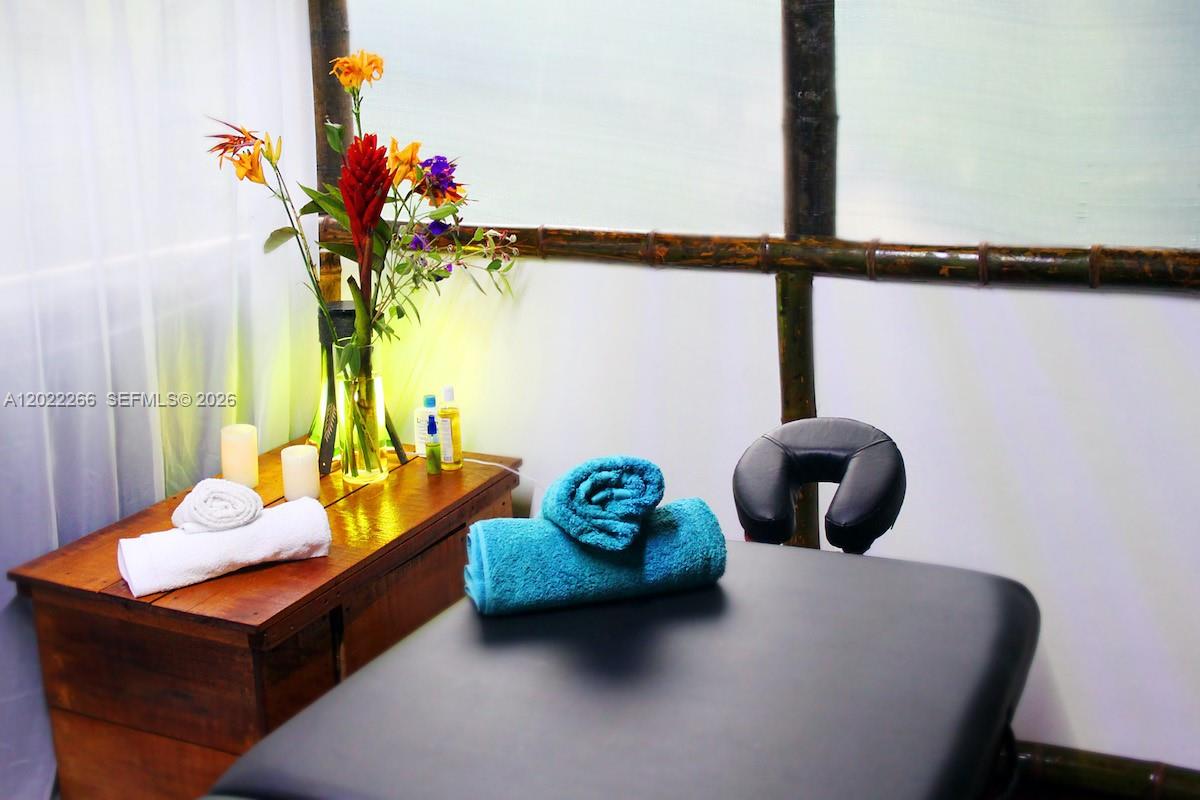 A massage table with towels sits in a room with bamboo-style wall accents — X Carretera, 00000, FL