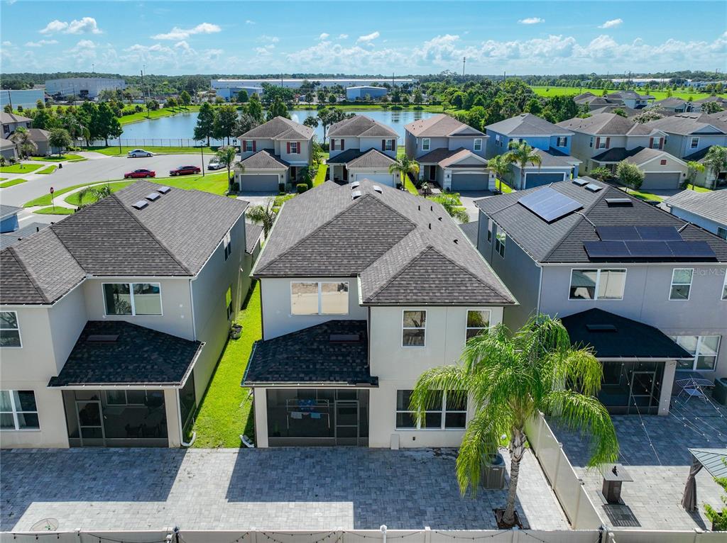 An aerial view of the rear exteriors of three suburban houses with paved patios — 480 ROCKY GROVE LANE, SANFORD, FL