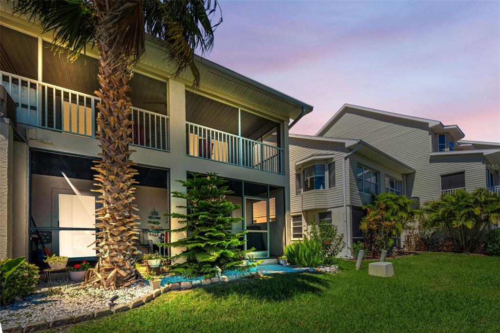 A two-story house with screened-in balconies and a palm tree in the backyard — 8238 AQUILA STREET, PORT RICHEY, FL