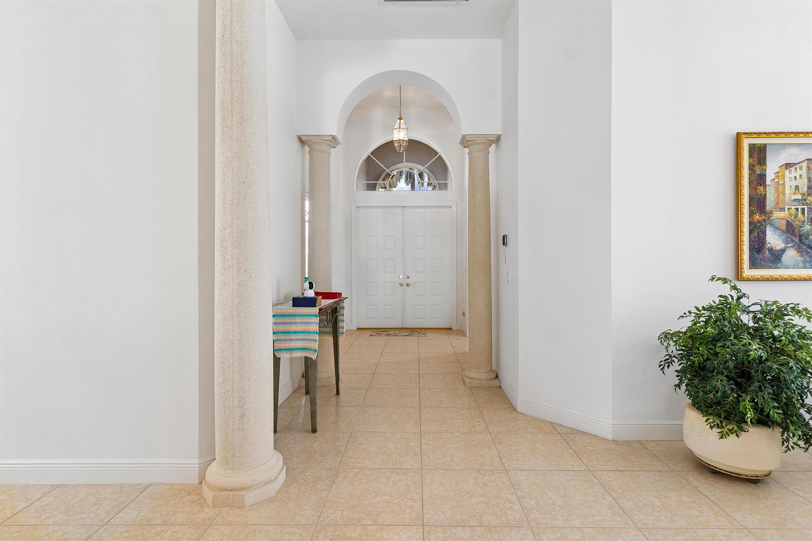 A bright entryway features tiled floors, two stone columns, and a double front door — 8102 Valhalla Drive, Delray Beach FL 33446, DELRAY BEACH, FL