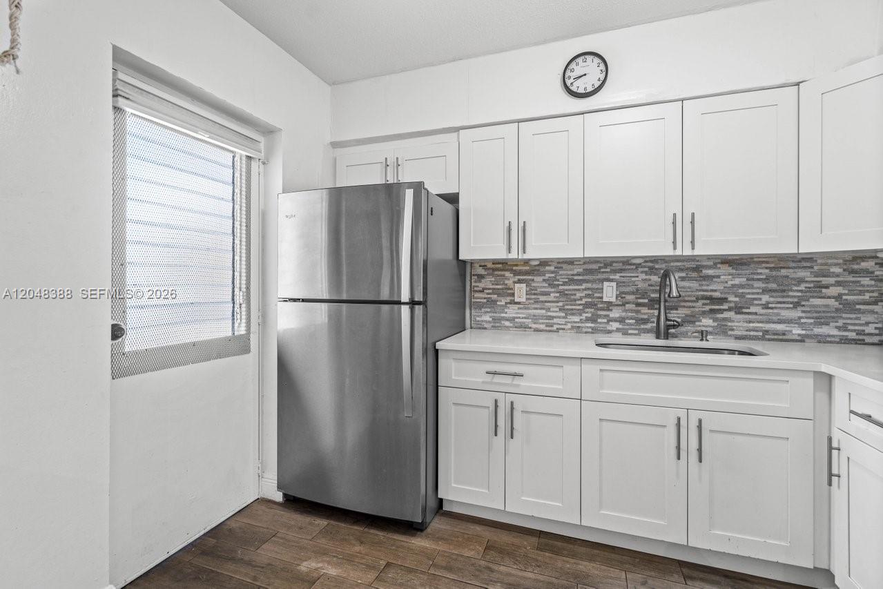 A kitchen features white cabinets, a stainless steel refrigerator, and a tiled backsplash — 260 NW 19th St # 26, Boca Raton FL 33432, BOCA RATON, FL