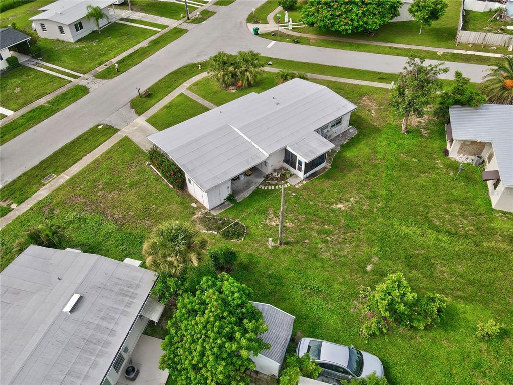 An aerial view shows a single-story house with a metal roof and a large yard — 22018 CATHERINE AVENUE, PORT CHARLOTTE, FL