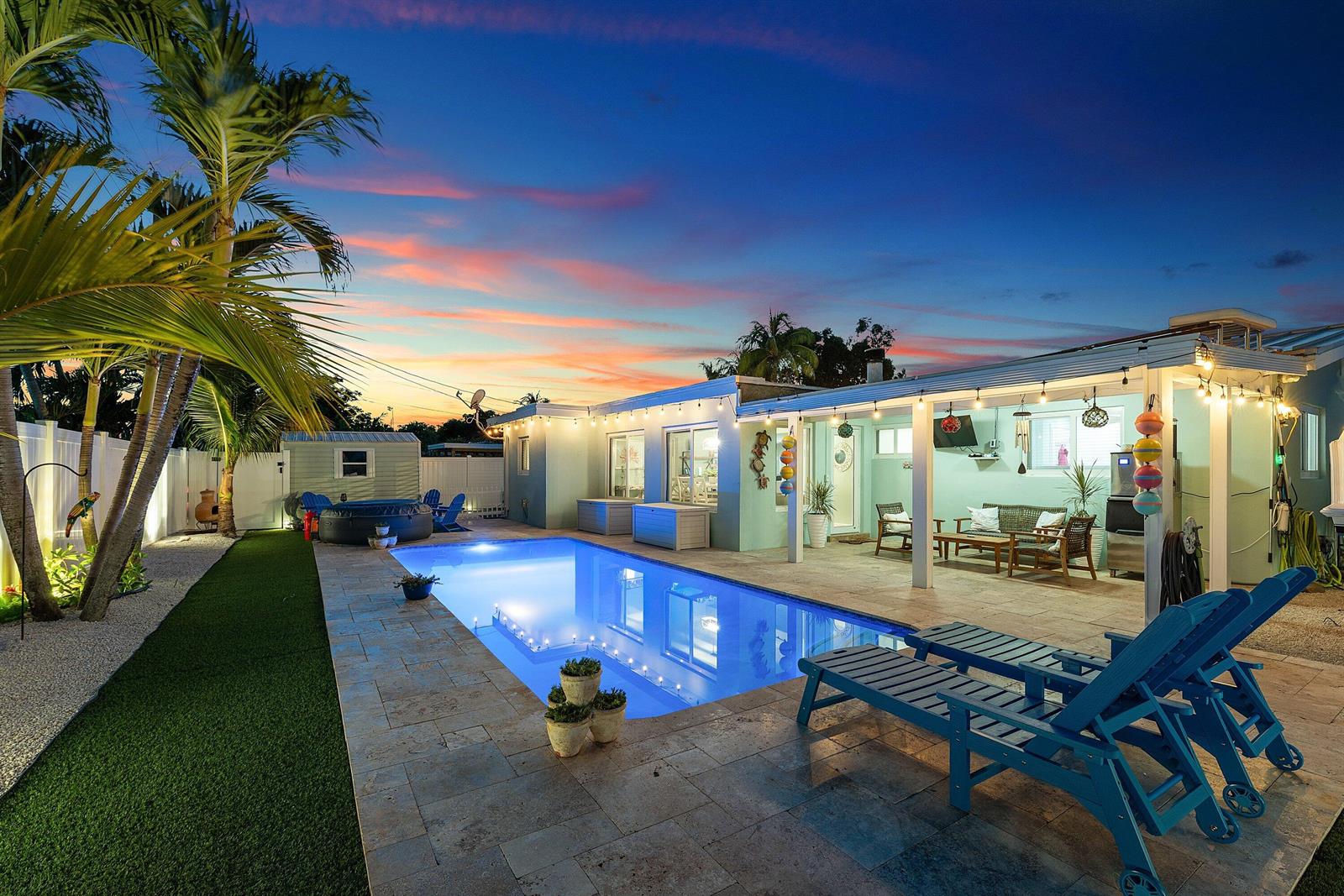 An outdoor patio with a swimming pool, lounge chairs, and string lights at sunset — 904 SE 15th Court, Deerfield Beach FL 33441, DEERFIELD BEACH, FL