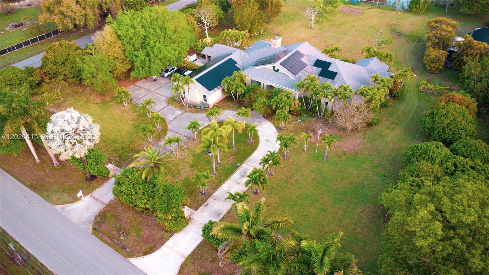 An aerial view shows a single-story house with solar panels and a long driveway — 20175 SW 256th St, Homestead FL 33031, HOMESTEAD, FL