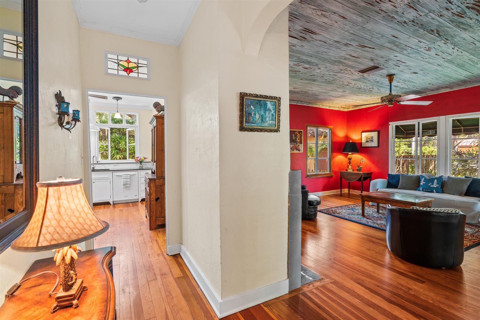 A view from a hallway into a kitchen and a living room with red walls — 825 Alamanda Street, Boca Raton FL 33486, BOCA RATON, FL