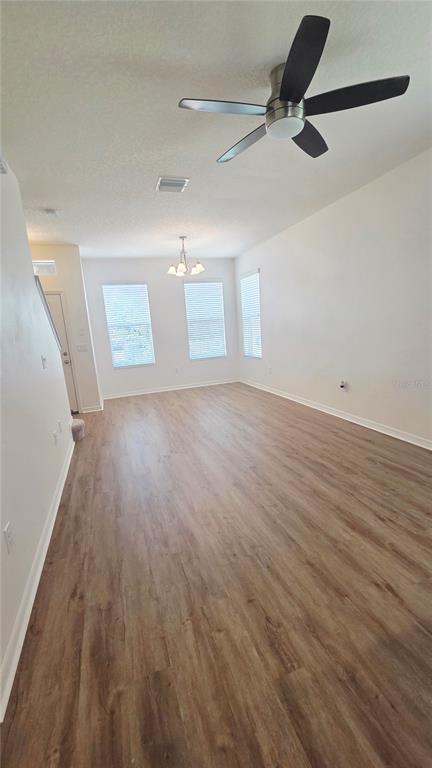 An empty living room features light wood-look flooring, white walls, and a ceiling fan — 8821 WALNUT GABLE COURT, RIVERVIEW, FL