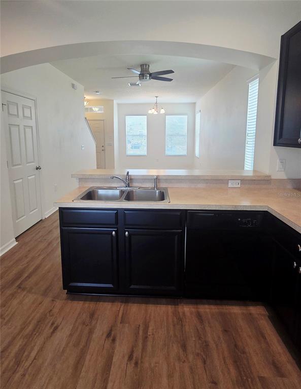 A kitchen features dark cabinets, a double sink, and a breakfast bar overlooking a room — 8821 WALNUT GABLE COURT, RIVERVIEW, FL