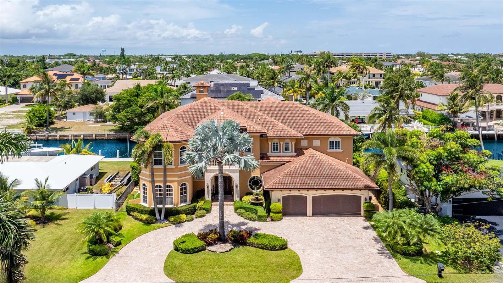 An aerial view of a two-story Mediterranean-style house with a tile roof and paved driveway — 929 Banyan Drive, Delray Beach FL 33483, DELRAY BEACH, FL