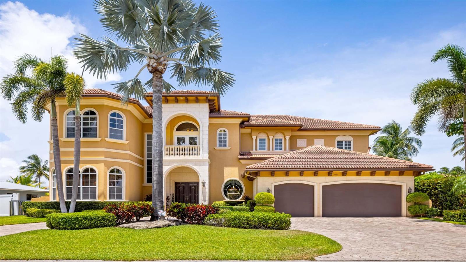 A two-story Mediterranean-style house with a tile roof, a three-car garage, and palm trees — 929 Banyan Drive, Delray Beach FL 33483, DELRAY BEACH, FL
