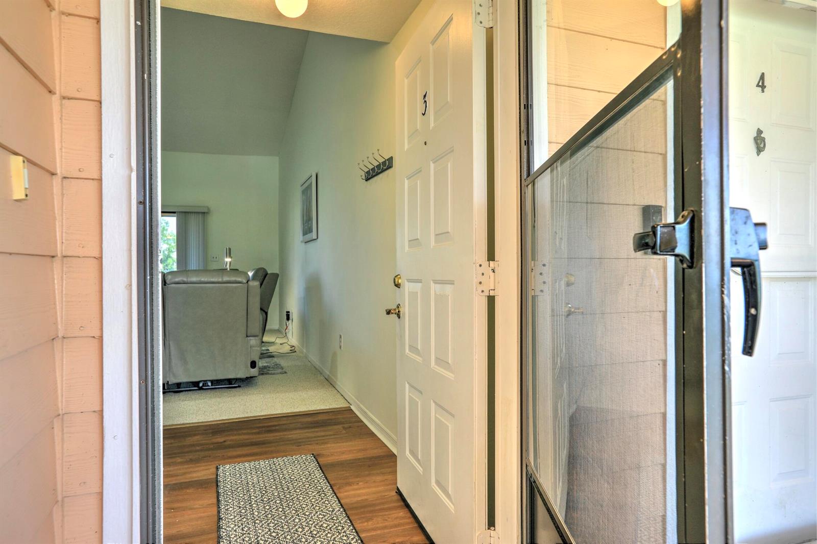 An open front door reveals an entryway with wood-look flooring leading into a living area — 5720 Pelican Pointe Drive # 3, Sebastian FL 32958, SEBASTIAN, FL