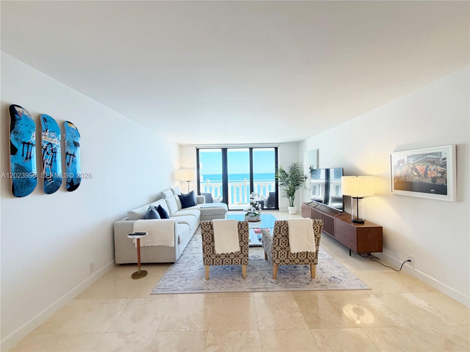 A living room features a sectional sofa, two patterned armchairs, and a view of the ocean — 1111 Crandon Blvd # B1105, Key Biscayne FL 33149, KEY BISCAYNE, FL