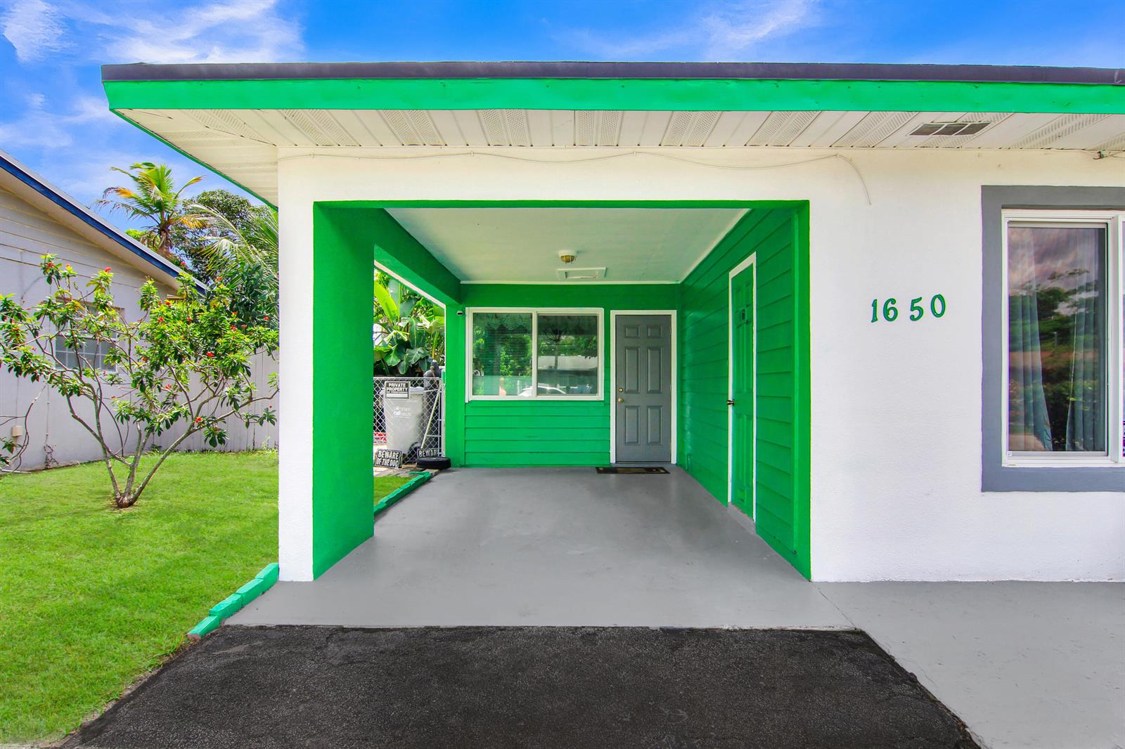 A backyard features a rectangular swimming pool, a grassy lawn, and a wooden privacy fence — 1650 NW 1st Way, Pompano Beach FL 33060, POMPANO BEACH, FL