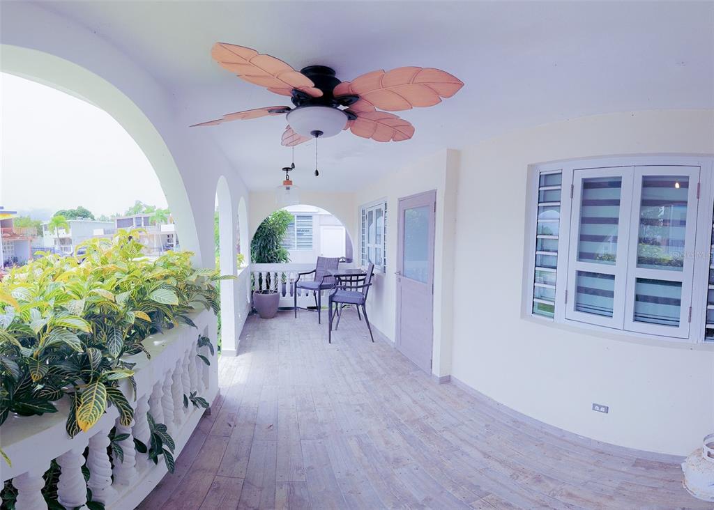 A covered outdoor balcony features a tropical-style ceiling fan, tile flooring, and a balustrade railing — Coco Beach S 110 GAVIOTA UNIT 110, RIO GRANDE, PR