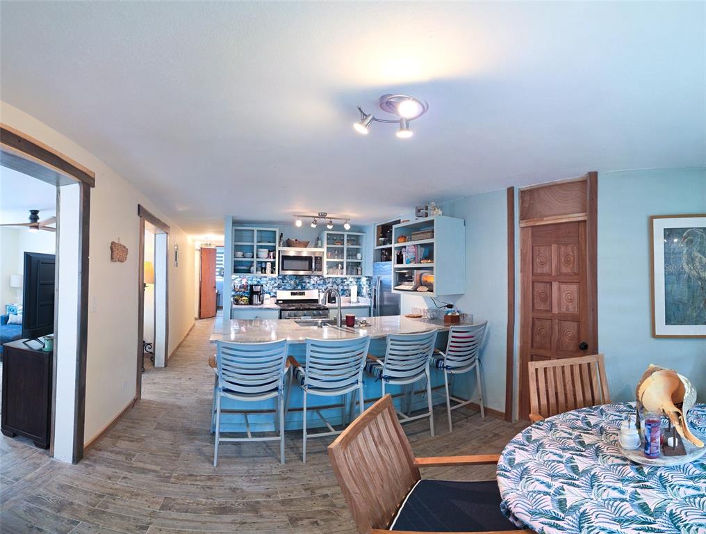 A kitchen with a breakfast bar, light blue cabinets, and a dining area — Coco Beach S 110 GAVIOTA UNIT 110, RIO GRANDE, PR